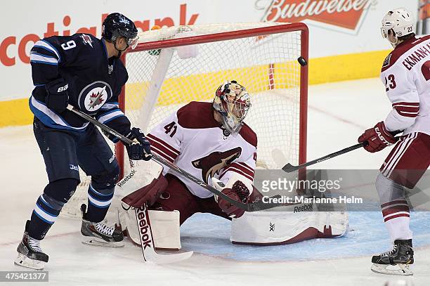 Evander Kane of the Winnipeg Jets and Mike Smith of the Phoenix Coyotes watch the puck hit the post in third-period action in an NHL game at the MTS...
