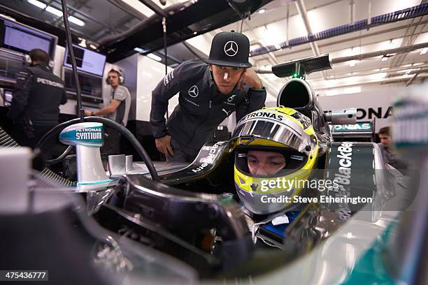 Lewis Hamilton looks on as Nico Rosberg of Germany and Mercedes GP prepares to drive during Formula One Winter Testing at the Circuito de Jerez on...
