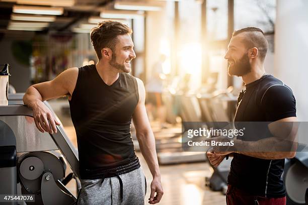 two young men talking to each other in health club. - gym friends stock pictures, royalty-free photos & images