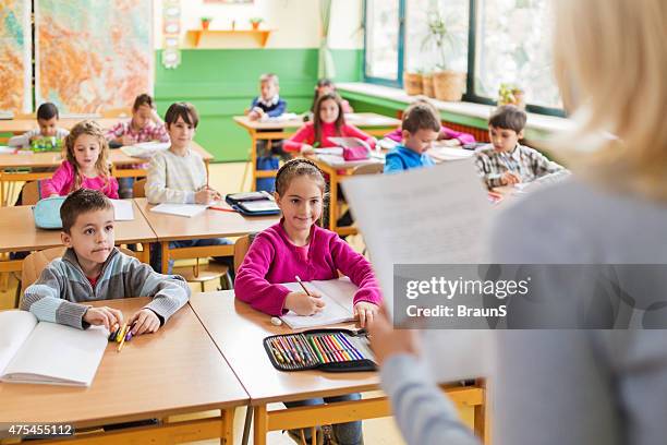 large group of smiling elementary students attending a class. - teacher taking attendance stock pictures, royalty-free photos & images