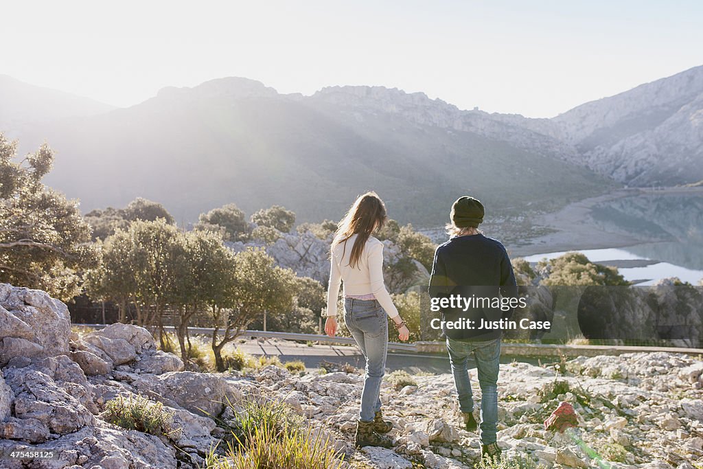 Young couple walking down a mountain in the sun