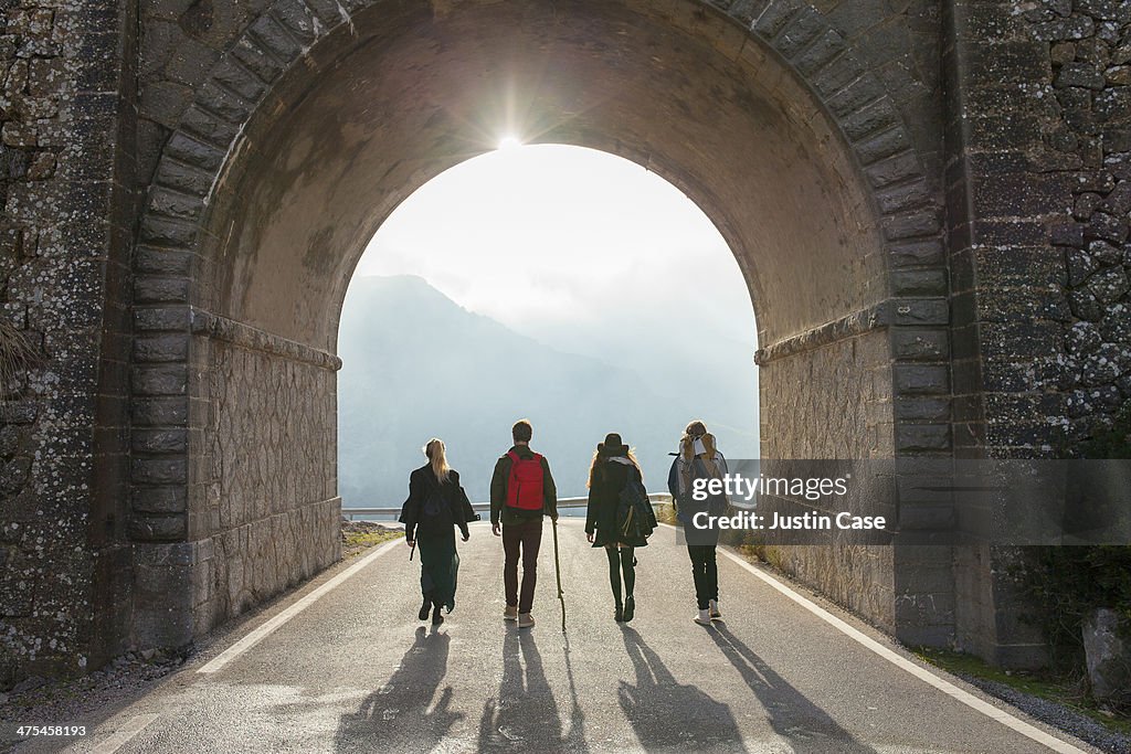 Young people going through a sunny tunnel