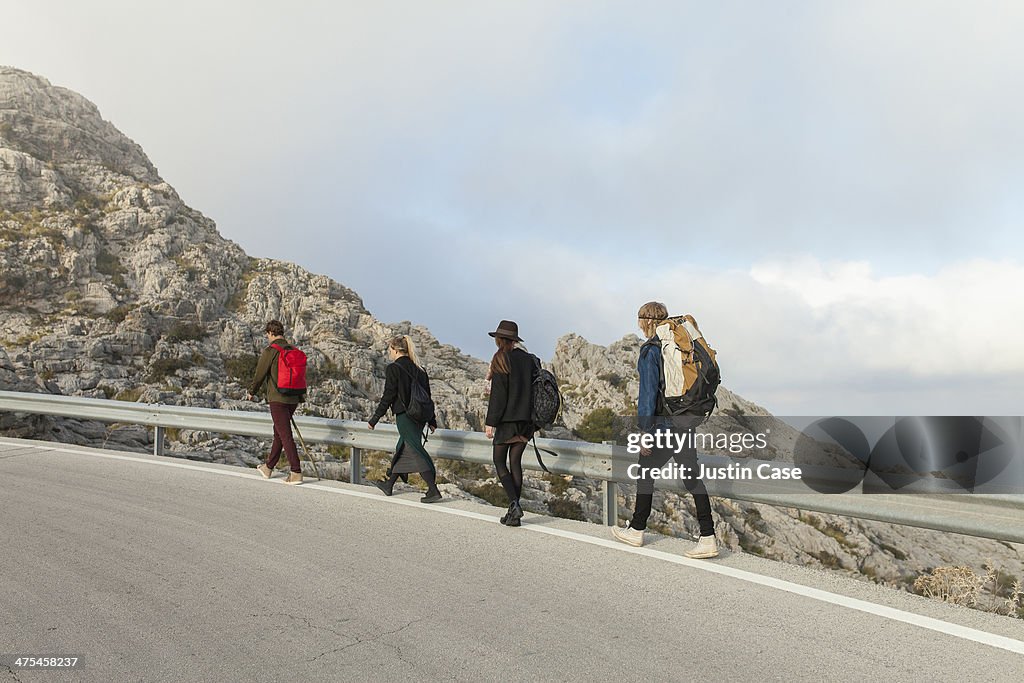 Young people walking on the road by the montains