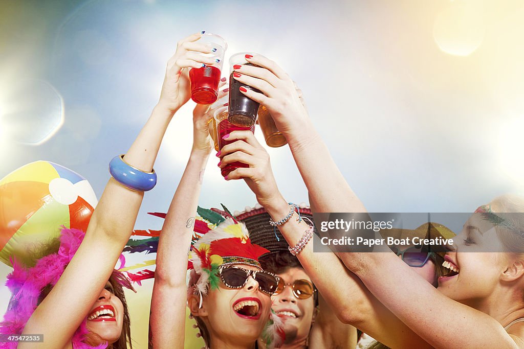 Group of friends making cheers salute with drinks