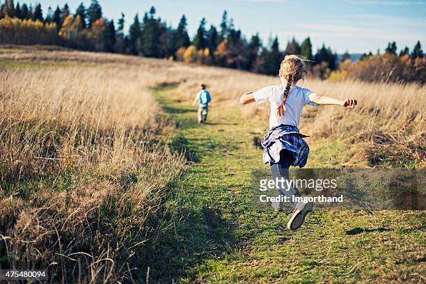 glückliche kleine kinder wandern - running midair stock-fotos und bilder