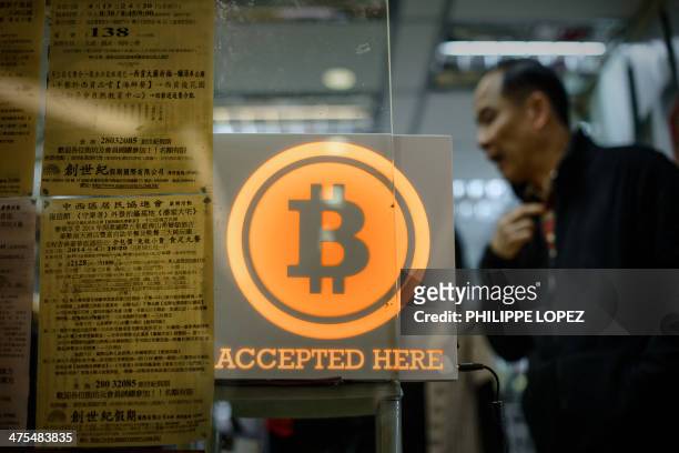Man walks out of a shop displaying a bitcoin sign during the opening ceremony of the first bitcoin retail shop in Hong Kong on February 28, 2014....