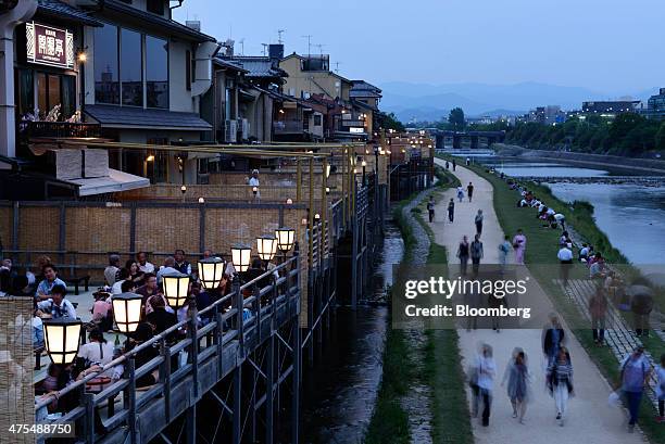 People dine at restaurants along the Kamogawa river in Kyoto, Japan, on Thursday, May 28, 2015. Spending by visitors to Japan jumped to the highest...