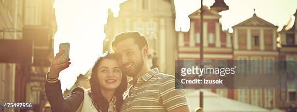 young couple taking selfie in the city at sunset - poznan poland stock pictures, royalty-free photos & images