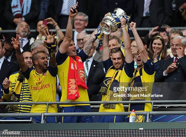 Arsenal's Aaron Ramsey lifts the FA Cup as Theo Walcott, Olivier Giroud and Nacho Monreal celebrate after FA Cup Final between Aston Villa and...