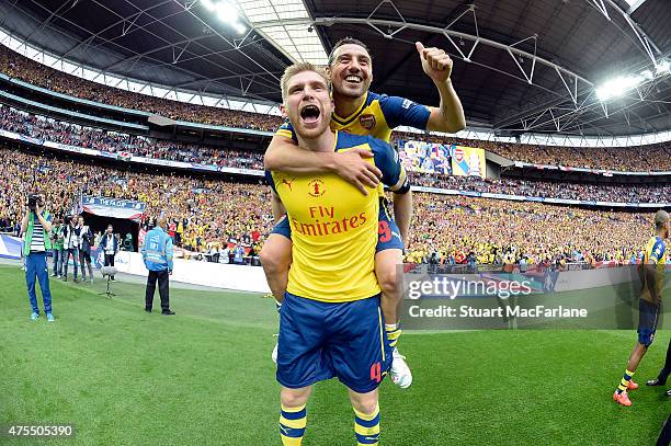 Arsenal's Per Mertesacker and Santi Cazorla celebrate after the FA Cup Final between Aston Villa and Arsenal at Wembley Stadium on May 30, 2015 in...