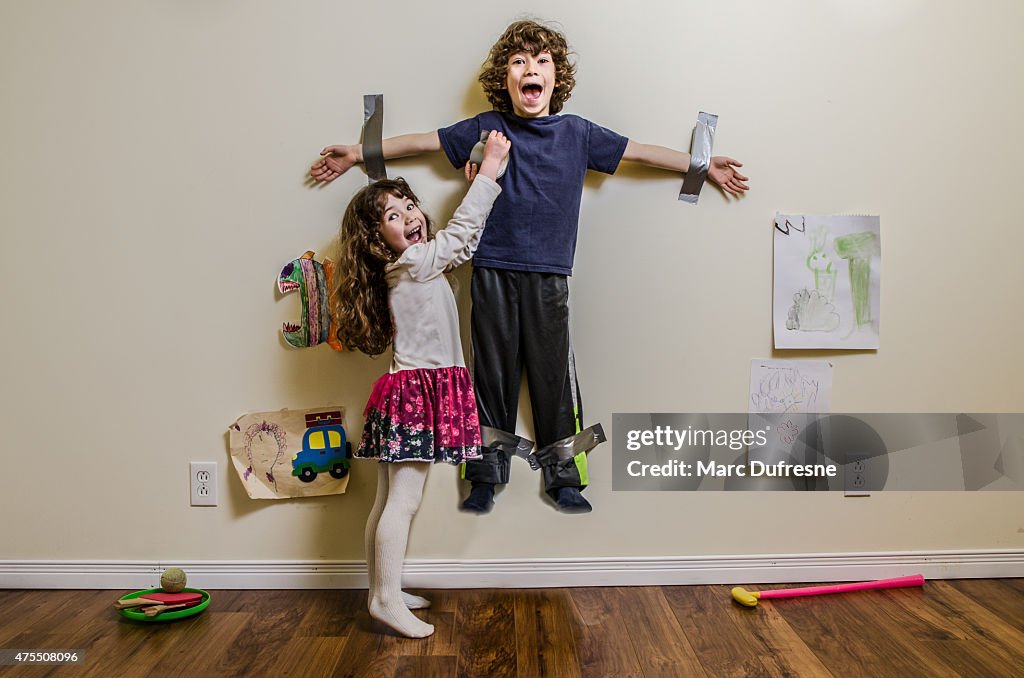 Kid being duct taped on wall by his sister