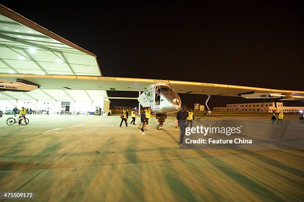 Ground crew move out the solar-powered aircraft Solar Impulse2 for takeoff at the airport, for a six-day non-stop flight over the Pacific Ocean to...