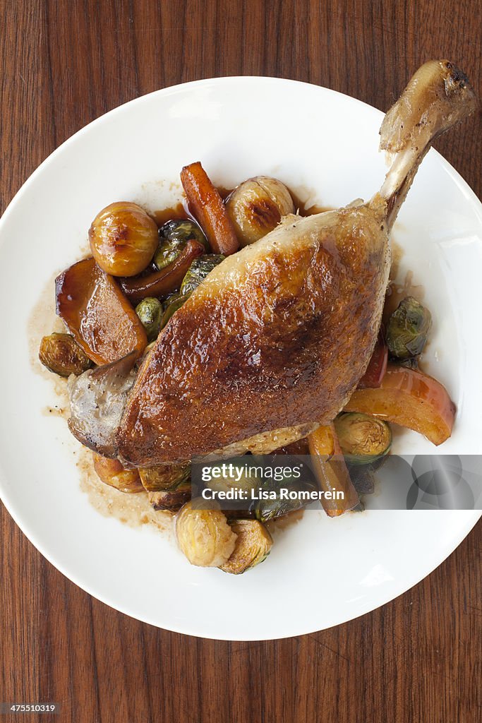 Plate of crispy duck leg with winter vegetables