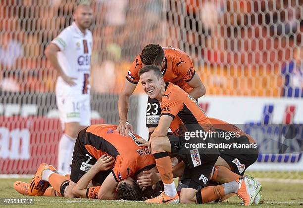 Liam Miller of the Roar is jumped on by his team mates as they celebrate victory during the round 21 A-League match between Brisbane Roar and Perth...