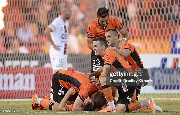 Liam Miller of the Roar is jumped on by his team mates as they celebrate victory during the round 21 A-League match between Brisbane Roar and Perth...