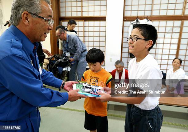 Children receive stationery as they were forced to evacuate as Mount Shindake of Kuchinoerabu Island erupted, at an evacuation center on May 30, 2015...