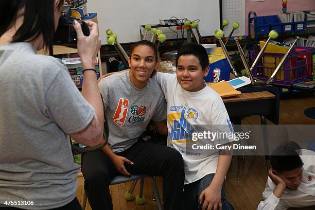 Courtney Clements of the Chicago Sky poses for a photo with a volunteer at Kilmer Elementary School as part of WNBA Cares Week 2015 on May 30, 2015...