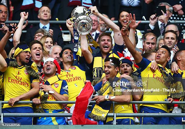 Mikel Arteta and Per Mertesacker of Arsenal lift the trophy as they celebrate with team mates during the FA Cup Final between Aston Villa and Arsenal...