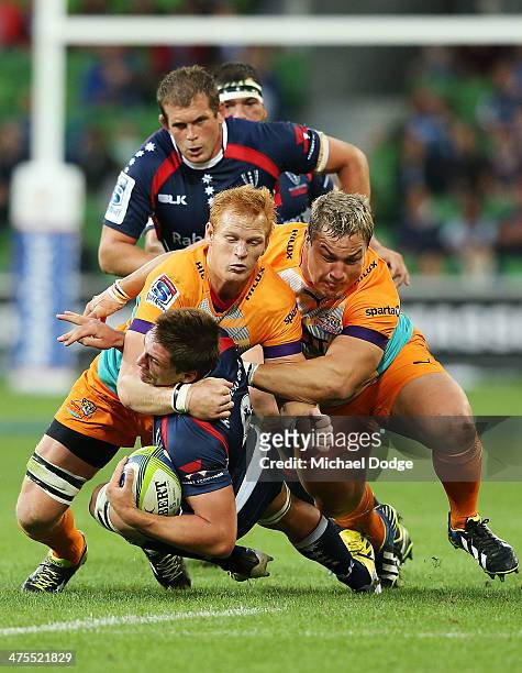 Philip van der Walt and Coenie Oosthuizen of the Cheetahs tackle Sean McMahon of the Rebels from making a try during the round three Super Rugby...
