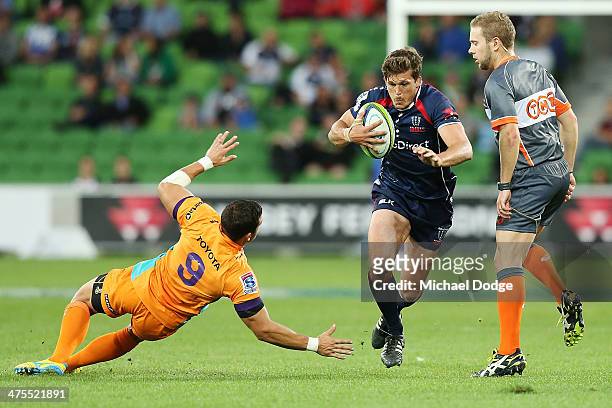 Luke Burgess of the Rebels runs with the ball away from Shaun Venter of the Rebels during the round three Super Rugby match between the Melbourne...