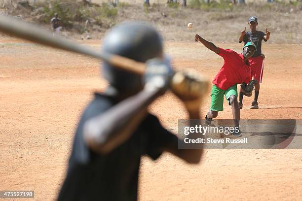 Player acts as umpire holding up the count as the pitcher lets one loose at the Academia de Beisbol Rafael Mejia S. Rafael Mejia Santana, a.k.a....