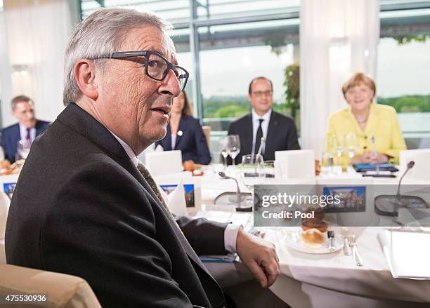 European Union Commission President Jean-Claude Juncker, French President Francois Hollande and German Chancellor Angela Merkel sit down for dinner...