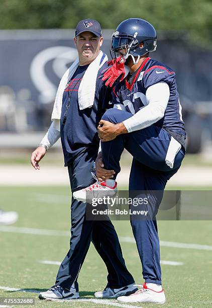 Head coach Bill O'Brien of the Houston Texans talks with Arian Foster of the Houston Texans work out during an NFL football organized team activity,...