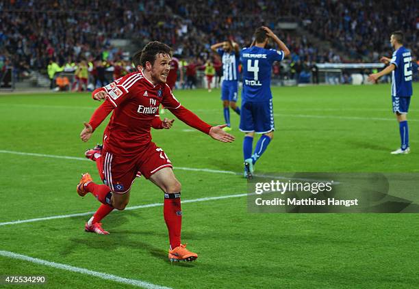 Despair for Karlsruher SC defenders as Nicolai Mueller of Hamburger SV celebrates as he scores their second goal during the Bundesliga play-off...