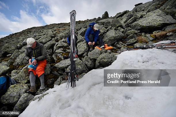 John Christie and Bill LaCasse get their boots on as they prepare to ski the snow fields near the top of Mt. Washington Friday, May 22, 2015.