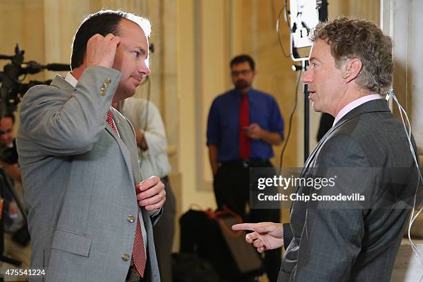 Sen. Rand Paul talks with U.S. Sen. Mike Lee in between television interviews in the Russell Senate Office Building rotunda on Capitol Hill June 1,...