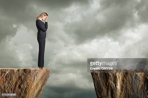 bestürzt geschäftsfrau stehen am rand einer klippe - cliff edge stock-fotos und bilder