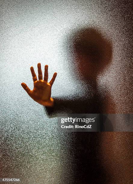 junge hinter glastür, vertikal - kindesmissbrauch stock-fotos und bilder