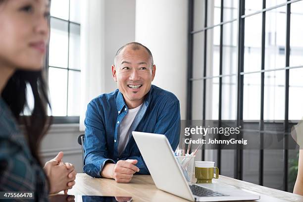 asian man smiling in business meeting - composition stock pictures, royalty-free photos & images