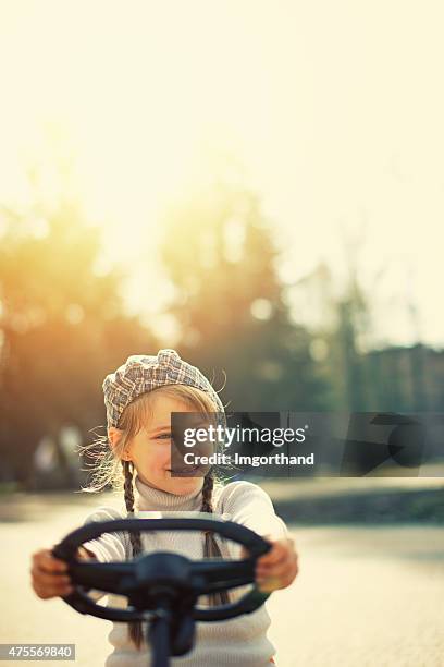 little girl driving gokart in the park - girl bike stock pictures, royalty-free photos & images