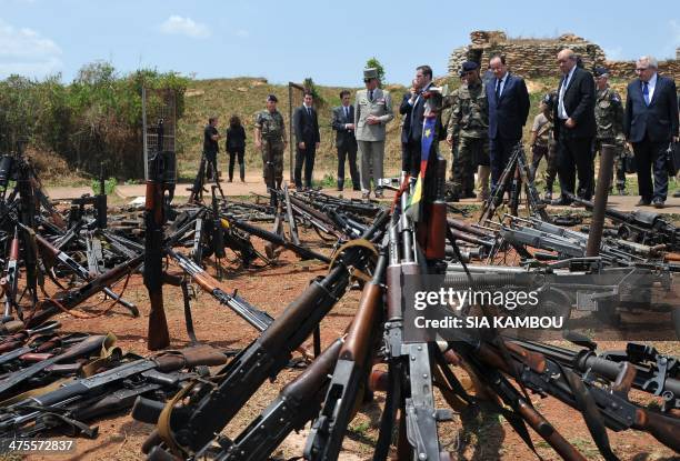 French President Francois Hollande , French Foreign Minister Laurent Fabius and French Defense Minister Jean-Yves Le Drian inspect arms confiscated...