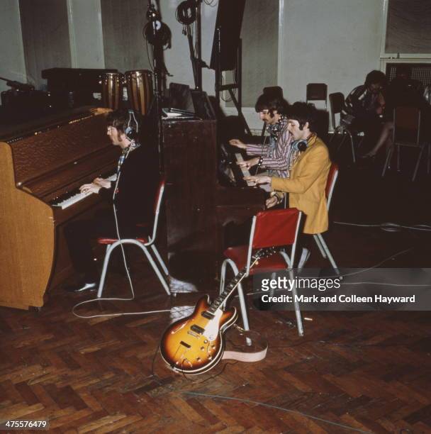 The Beatles play pianos at Abbey Road Studios, London, circa 1967. Left to right: John Lennon , Ringo Starr and Paul McCartney. George Harrison is...