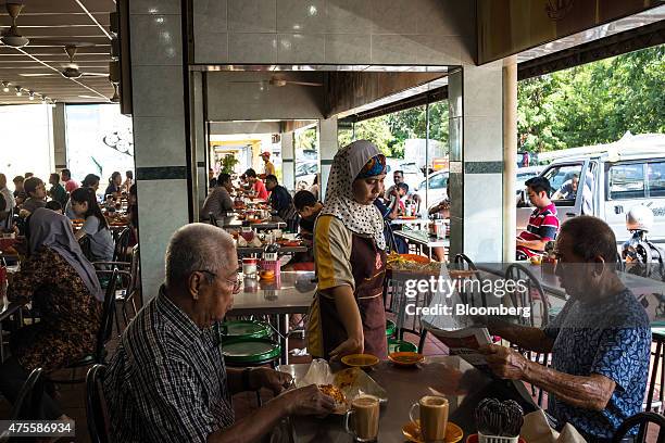 Waitress serves customers at a restaurant in the Pandamaran area of Klang, Selangor, Malaysia, on Wednesday, May 27, 2015. Malaysia's ringgit fell...