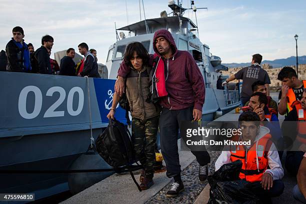 Migrant man is escorted to an ambulance after being picked up in a dinghy offshore making his way from Turkey on June 02, 2015 in Kos, Greece....