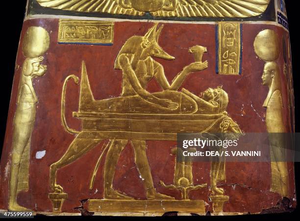 Anubis in the throes of performing the ritual of embalming, decorative detail of a male funeral mask, painted and gilded cartonnage, from Meir....