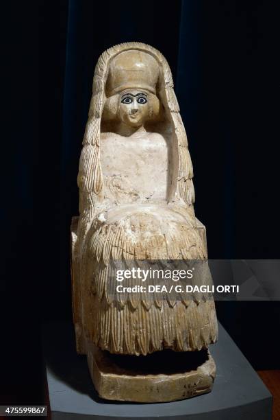 Woman sitting wearing kaunakes, fleece cloak made from goat hair or wool, and a polos headdress with veil, alabaster statue, from the Temple of...