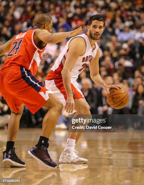 Toronto Raptors point guard Greivis Vasquez looks to pass while being guarded by Washington Wizards point guard Andre Miller during the game between...