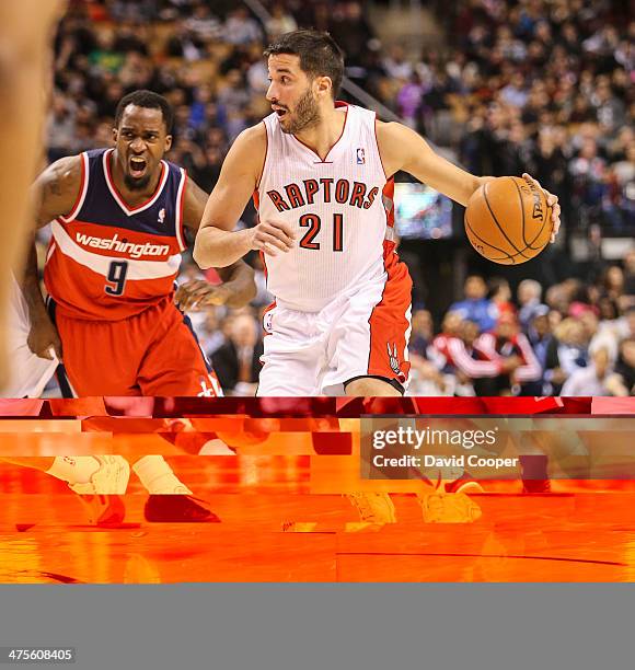 Toronto Raptors point guard Greivis Vasquez looks to pass while being chased by Washington Wizards small forward Martell Webster during the game...