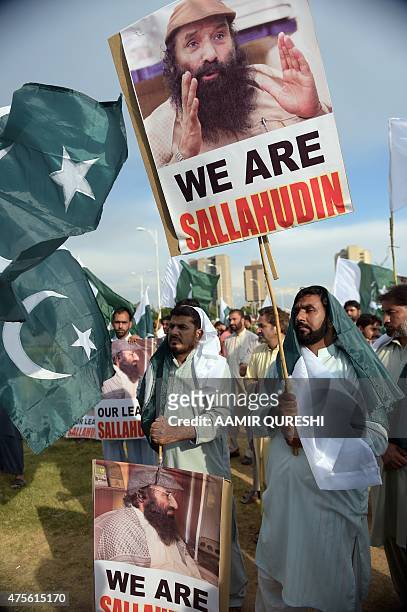 Pakistani supporters of political and Islamic party Jammat-e-Islami shout anti-Indian slogans as they hold placards with images of Syed Salahuddin,...