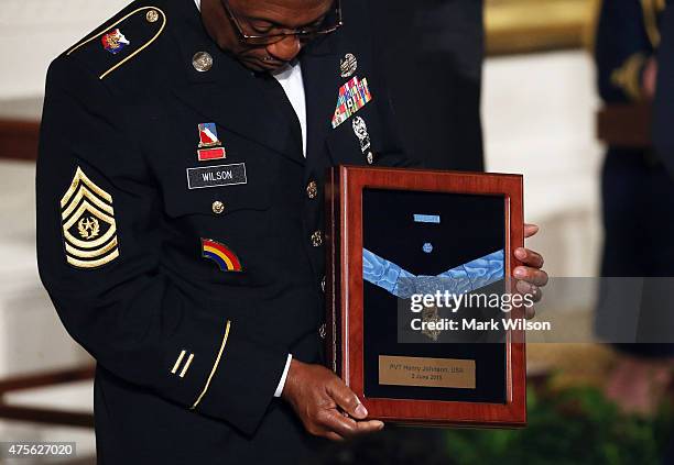 Command Sergeant Major Louis Wilson of the New York National Guard, holds a Medal of Honor after accepting it on behalf of the late Army Private...
