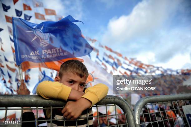 Child stands behind a fence during a campaign rally by Turkish Prime Minister and leader of the ruling Justice and Development Party in Istanbul on...