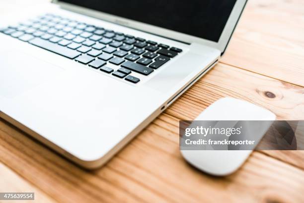 macbook pro laptop on the desk - macbook business stockfoto's en -beelden