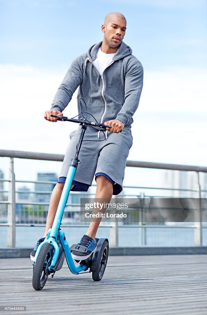 Young black male using outdoor fitness device