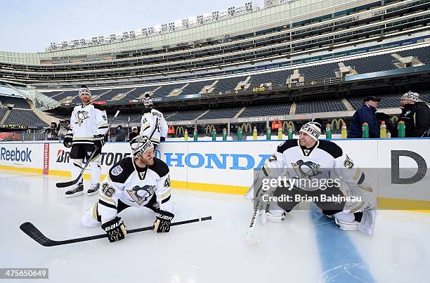 Joe Vitale and goaltender Jeff Zatkoff of the Pittsburgh Penguins stretch as teammate Deryk Engelland looks on during the 2014 NHL Stadium Series...