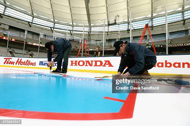 Ice crew members Eric King and Zach Cornwell set the crease during the 2014 Tim Horton NHL Heritage Classic build out before the game between the...