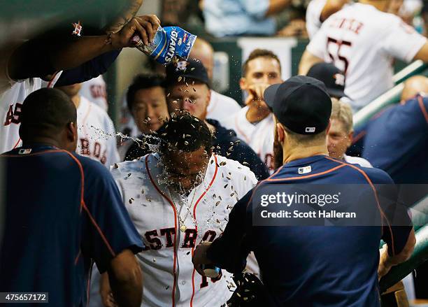 Luis Valbuena of the Houston Astros get showered with water and seeds in the dugout after a solo home run in the third inning during their game...